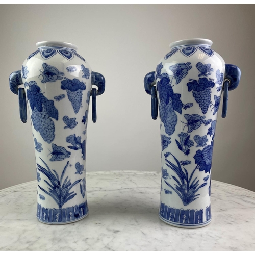 26 - CHINESE VASES, a pair, blue and white having butterflies, grapes and foliate decoration with elephan... 