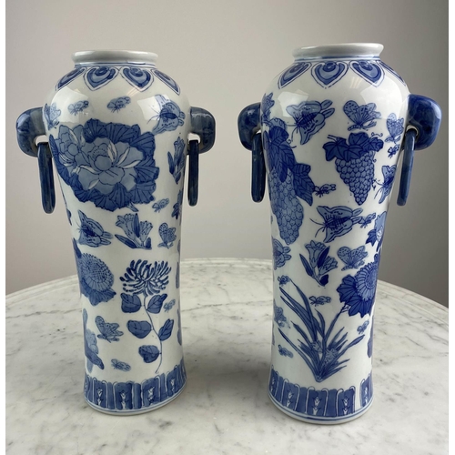 26 - CHINESE VASES, a pair, blue and white having butterflies, grapes and foliate decoration with elephan... 