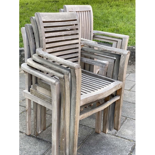 355 - GARDEN TABLE AND ARMCHAIRS, weathered, eight stacking armchairs included 64cm W, table 130cm W. (9)