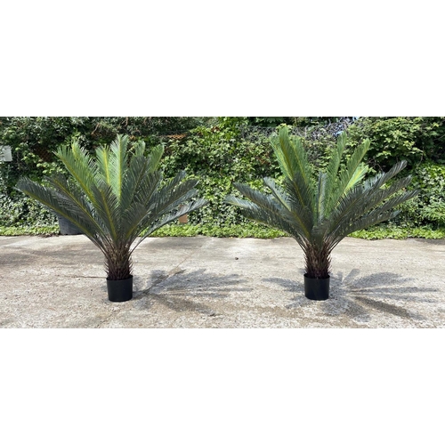 409 - FAUX FERN TREES, a pair, in black planters, 110cm high, 100cm wide. (2)