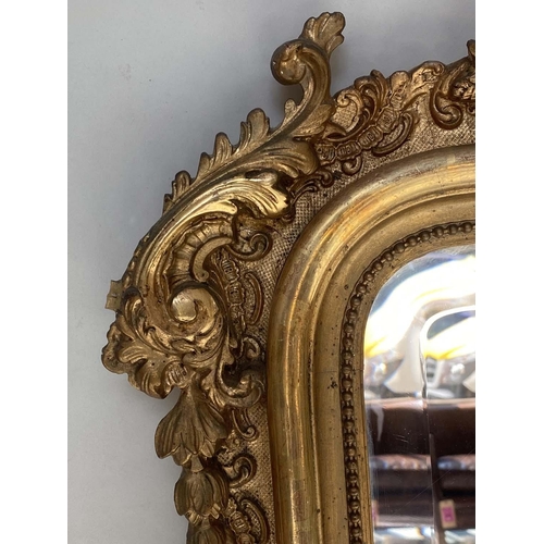 94 - OVERMANTEL MIRROR, 19th century French giltwood and gesso moulded with arched C scroll crest, beaded... 