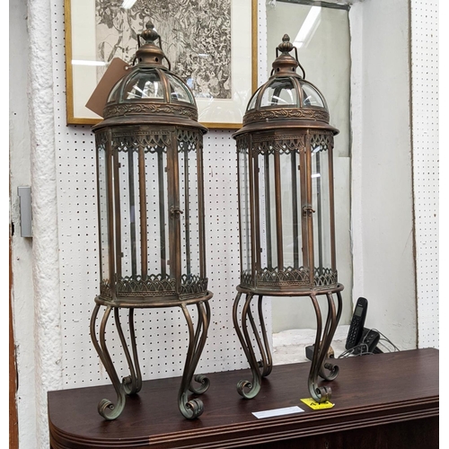 378 - STORM LANTERNS, a pair, on stands coppered metal and glazed, regency style, 92cm H. (2)