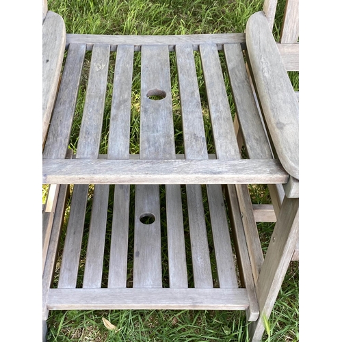 144 - CONVERSATION GARDEN SEAT, weathered slatted teak with two armchairs and conjoining two tier table, 1... 