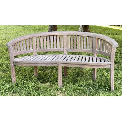 147 - BANANA GARDEN BENCH, weathered teak with curved back and slatted construction, 150cm W.