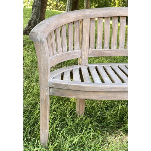 147 - BANANA GARDEN BENCH, weathered teak with curved back and slatted construction, 150cm W.