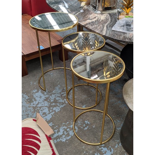 510 - SIDE TABLES, a set of three, largest 43cm x 63cm H, mirrored tops on gilt metal bases. (3)