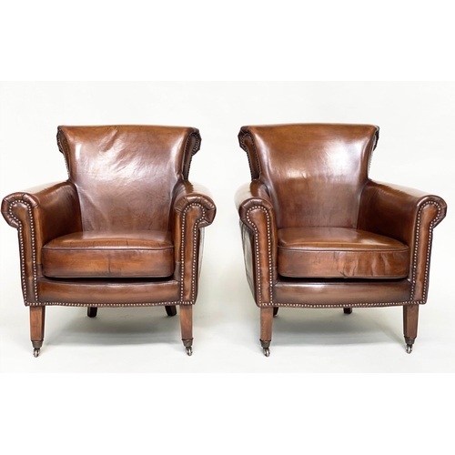 189 - ARMCHAIRS, a pair, club style brass studded tan leather with scroll arms and back and tapering suppo... 