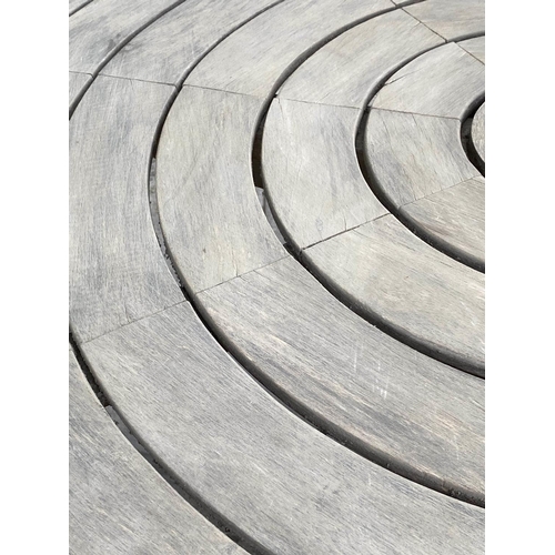 107 - CIRCULAR GARDEN TABLE, weathered teak with circular concentric slatted top and centre column support... 