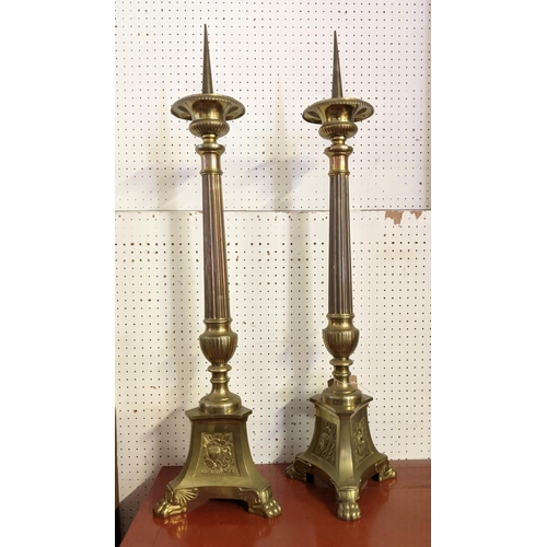 22 - PRICKET CANDLESTICKS, a pair, each 98cm tall, brass Ecclesiastical style. (2)