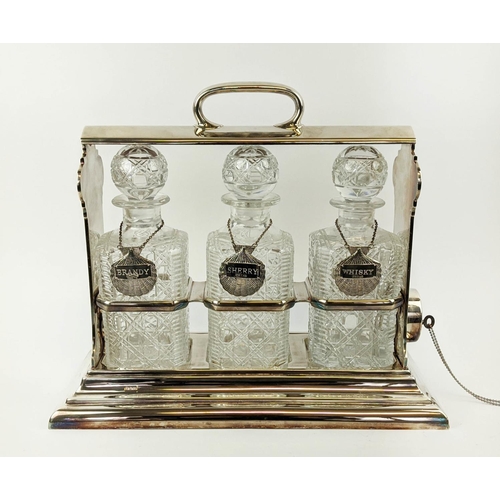 7 - A WALKER AND HALL SILVER PLATED TANTALUS fitted with three square cut glass decanters, carrying hand... 