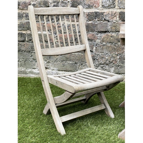 129 - CHILD'S GARDEN ARMCHAIRS, a pair, weathered teak, folding with spindle back together with a lattice ... 