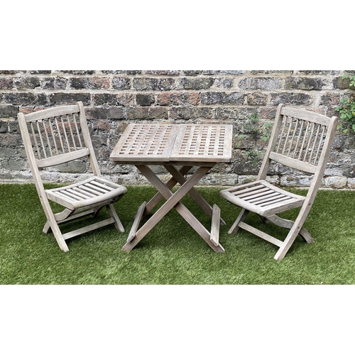 129 - CHILD'S GARDEN ARMCHAIRS, a pair, weathered teak, folding with spindle back together with a lattice ... 