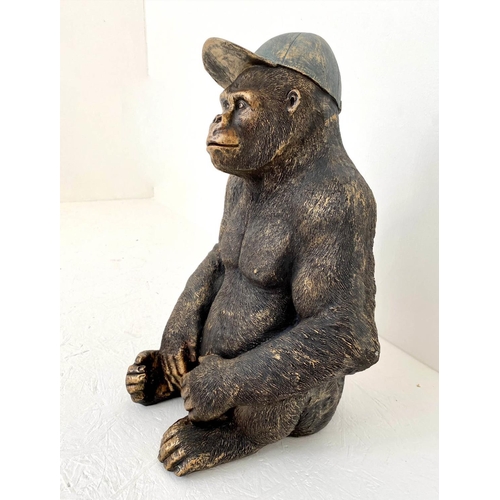 392 - GORILLA WEARING A BASEBALL CAP, 60cm H x 40cm W x 34cm D, faux bronze finish resin.