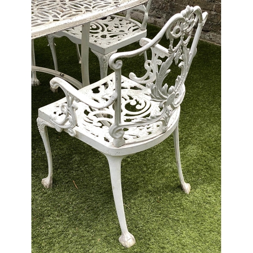 127 - GARDEN TABLE AND CHAIRS, weathered cast aluminium with pierced table and six matching chairs, one wi... 