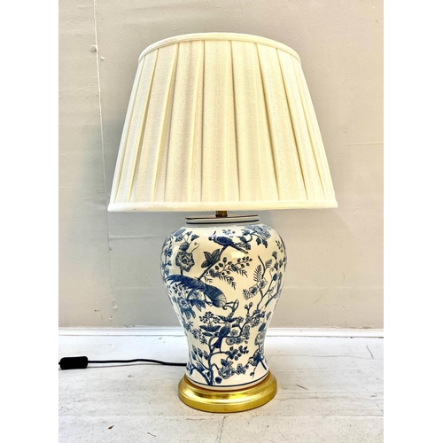 439 - TABLE LAMP, 55cm high, 35cm diameter, blue and white glazed ceramic, gilt base, with a pleated shade... 