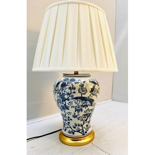 439 - TABLE LAMP, 55cm high, 35cm diameter, blue and white glazed ceramic, gilt base, with a pleated shade... 