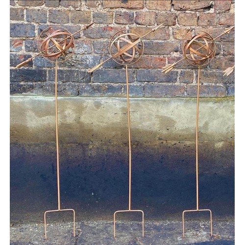 383 - ARMILLARY SPHERE GARDEN STAKES, a set of three, 115cm H x 39cm W x 17cm D, coppered metal finish. (3... 