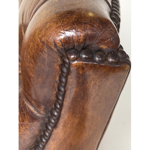 106 - ARMCHAIR AND STOOL, deep buttoned mid brown leather and brass studded upholstered with swept support... 