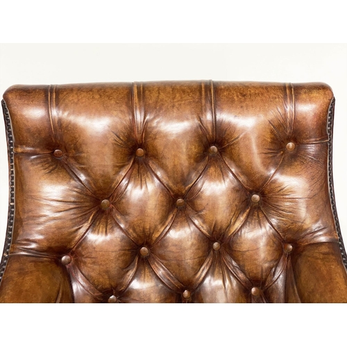 106 - ARMCHAIR AND STOOL, deep buttoned mid brown leather and brass studded upholstered with swept support... 