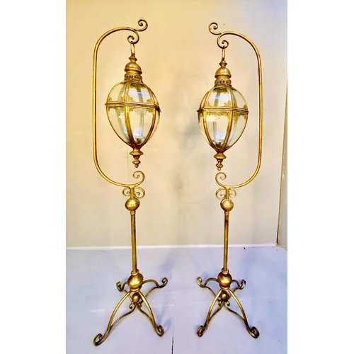 360 - STORM LANTERNS ON STANDS, a pair, 163cm high, 35cm wide, Regency style, gilt metal. (2)