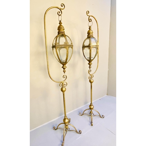 360 - STORM LANTERNS ON STANDS, a pair, 163cm high, 35cm wide, Regency style, gilt metal. (2)