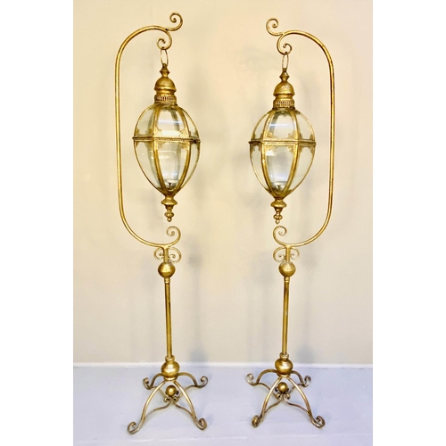 360 - STORM LANTERNS ON STANDS, a pair, 163cm high, 35cm wide, Regency style, gilt metal. (2)