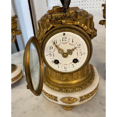 1 - CLOCK GARNITURE, French 19th century, having cupid mounted on top of the clock, with matching candel... 