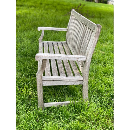 412 - GARDEN BENCH, weathered teak of slatted construction with shaped back and scroll arms, 152cm W.