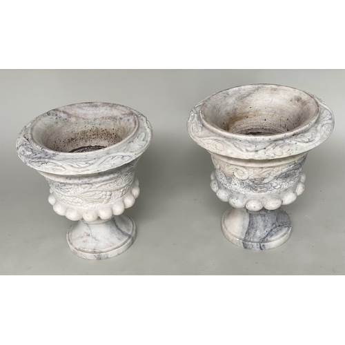 104 - MARBLE URNS, a pair, carved urns with ram's mask and swag foliate decoration, 40cm W x 40cm H. (2)