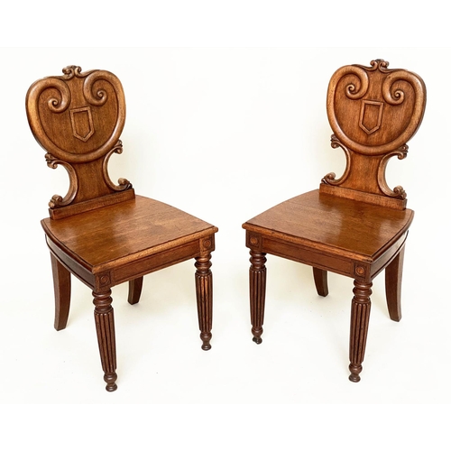 108 - HALL CHAIRS, a pair, 19th century oak each with scroll and escutcheon carved backs and reeded front ... 