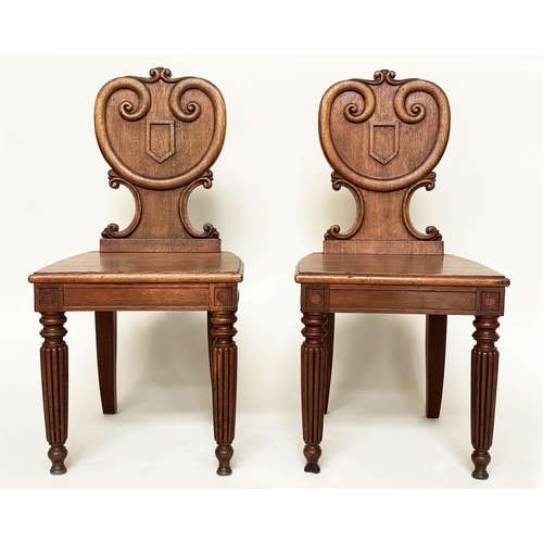 108 - HALL CHAIRS, a pair, 19th century oak each with scroll and escutcheon carved backs and reeded front ... 