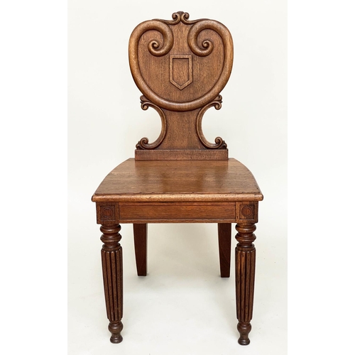 108 - HALL CHAIRS, a pair, 19th century oak each with scroll and escutcheon carved backs and reeded front ... 