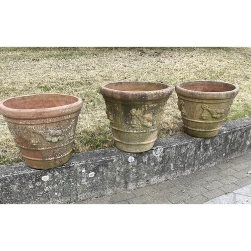 117 - GARDEN TERRACOTTA PLANTERS, a set of three, large weathered terracotta with fruit decoration, 57cm W... 