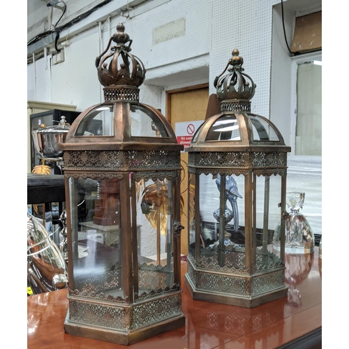 406 - STORM LANTERNS, a pair, 69cm H, aged metal and glazed.