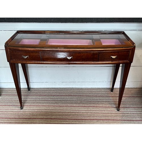 195 - BIJOUTERIE TABLE, 115cm W x 76cm H x 47cm D Art Deco manner with a glass top above three drawers on ... 