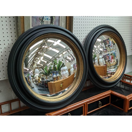 353 - CONVEX MIRRORS, a pair, 49cm diam ebonised  with a gilt inner slip. (2)