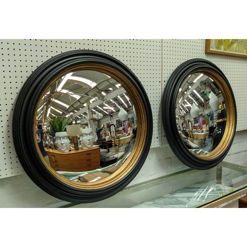 354 - CONVEX MIRRORS, a pair, 62cm diam ebonised with a gilt inner slip. (2)