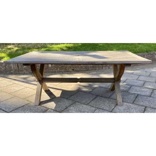 111 - GARDEN TABLE, weathered teak of substantial slatted construction with 'X' trestle and stretchered su... 