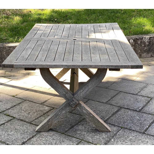 111 - GARDEN TABLE, weathered teak of substantial slatted construction with 'X' trestle and stretchered su... 