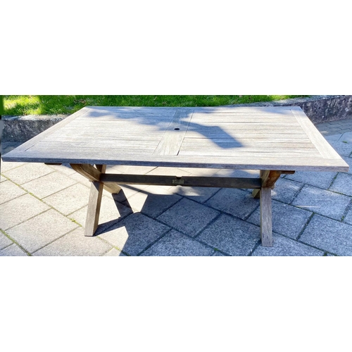 111 - GARDEN TABLE, weathered teak of substantial slatted construction with 'X' trestle and stretchered su... 