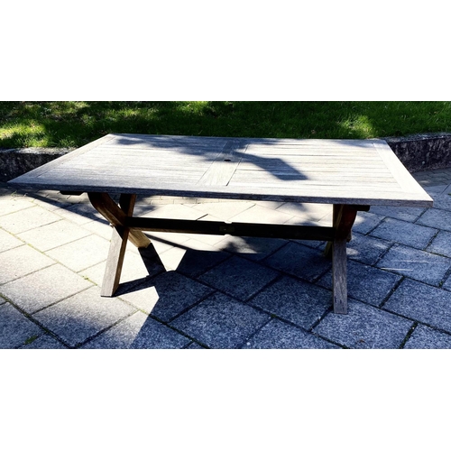 111 - GARDEN TABLE, weathered teak of substantial slatted construction with 'X' trestle and stretchered su... 