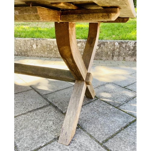 111 - GARDEN TABLE, weathered teak of substantial slatted construction with 'X' trestle and stretchered su... 