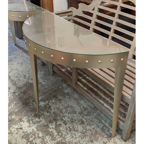 306 - DEMI-LUNE CONSOLE TABLES, a pair, 110cm W x 85cm H x 45cm D in a silvered finish with a studded frie... 