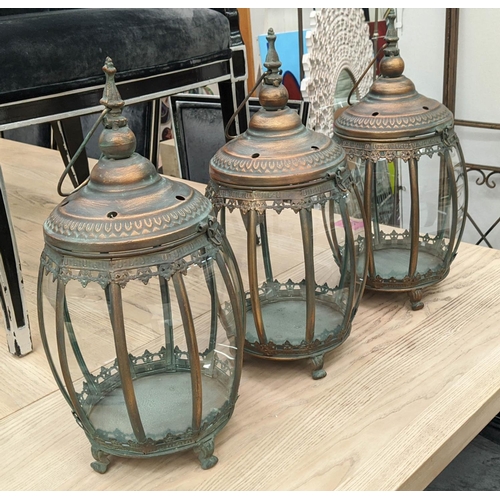 418 - HANGING LANTERNS, set of three, antiqued copper finish, barrel form, glazed sides, 46cm H x 25cm dia... 