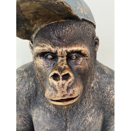 264 - GORILLA WEARING A BASEBALL CAP, 60cm H x 40cm W x 34cm D, faux bronze finish resin.