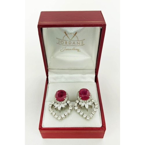 13 - A PAIR OF 18CT WHITE GOLD RUBY AND DIAMOND EARRINGS, each set with a single natural oval mixed cut r... 