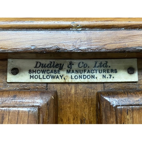 214 - HABERDASHERY CABINET, early/mid 20th century oak by Dudley & Co Ltd, with sixteen glazed drawers abo... 