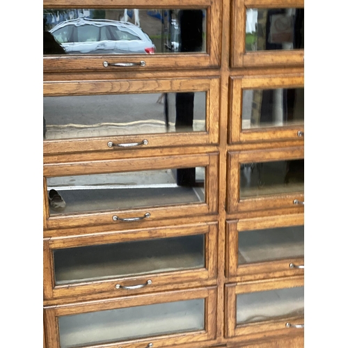 214 - HABERDASHERY CABINET, early/mid 20th century oak by Dudley & Co Ltd, with sixteen glazed drawers abo... 