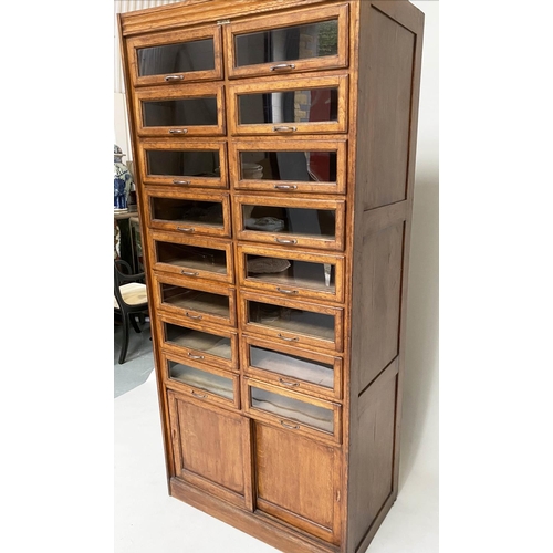 214 - HABERDASHERY CABINET, early/mid 20th century oak by Dudley & Co Ltd, with sixteen glazed drawers abo... 