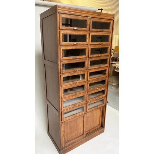 214 - HABERDASHERY CABINET, early/mid 20th century oak by Dudley & Co Ltd, with sixteen glazed drawers abo... 